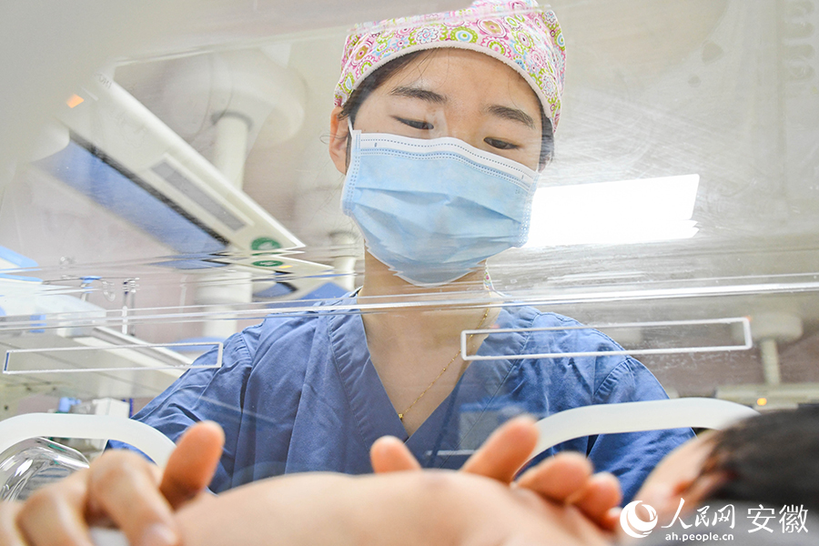 “临时妈妈”仔细安抚着新生儿。人民网 周坤摄